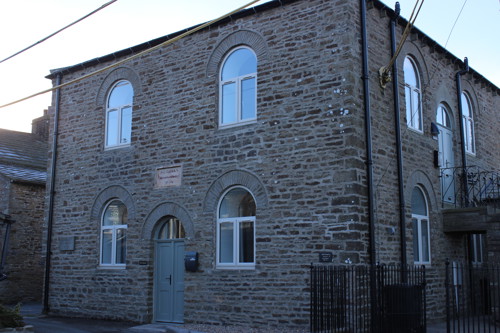 A renovated stone building with arched windows.